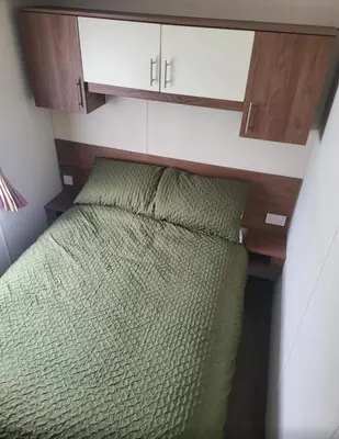 a bedroom with a green bed in a room at River View Modern 3 Bedroom Pet Friendly in Clarach Bay in Aberystwyth