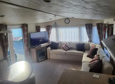 a living room with a couch and a tv at River View Modern 3 Bedroom Pet Friendly in Clarach Bay in Aberystwyth