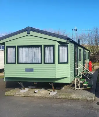 a green train car parked in a parking lot at River View Modern 3 Bedroom Pet Friendly in Clarach Bay in Aberystwyth