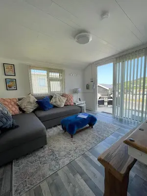 a living room with a couch and a table at Awel Mor Beautiful Pet Friendly Chalet in Clarach Bay in Aberystwyth