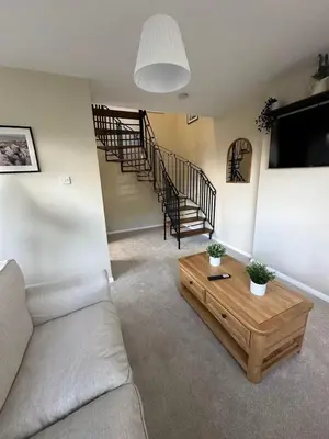 a living room with a couch and a wooden coffee table at Hucklemarsh House in Ludlow