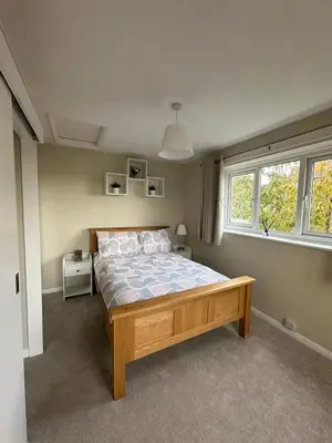 a bedroom with a bed and two windows at Hucklemarsh House in Ludlow