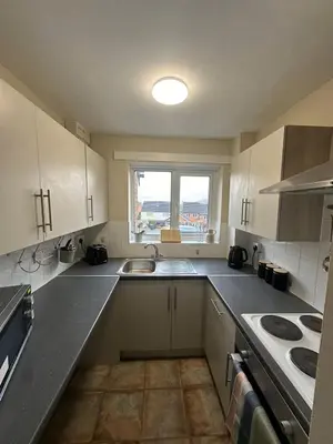 a kitchen with white cabinets and a sink and a window at Hucklemarsh House in Ludlow