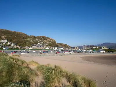 a sandy beach with a town in the background at Gilfach Bach in Dolgellau