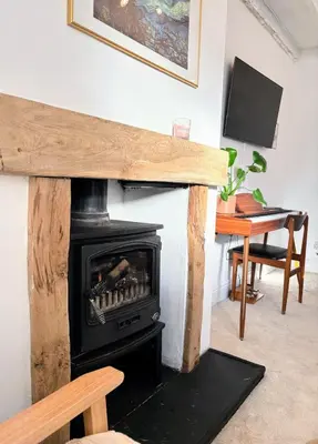 a fireplace in a living room with a stove at Charming Stone Cottage Getaway in Dolgellau