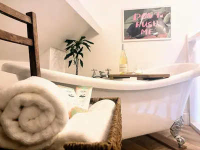 a bathroom with a bath tub and a sink at Charming Stone Cottage Getaway in Dolgellau