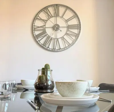 a table with plates and a clock on the wall at Charming Stone Cottage Getaway in Dolgellau