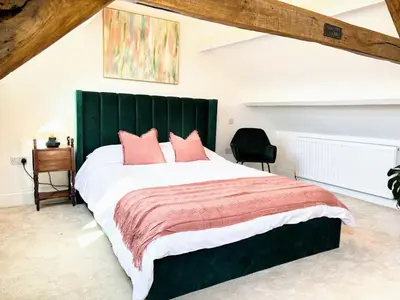 a bedroom with a large bed with a green headboard at Charming Stone Cottage Getaway in Dolgellau