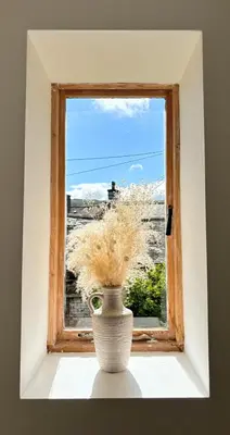 a vase sitting on a window sill with a plant at Charming Stone Cottage Getaway in Dolgellau