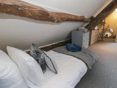 a bedroom with a bed with white sheets and pillows at Penygrisiau in Barmouth