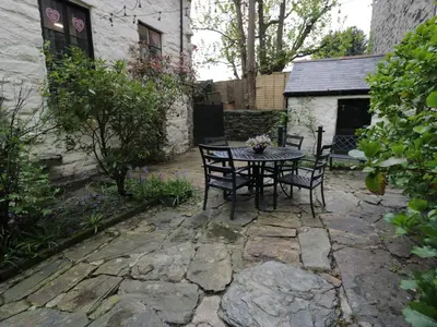 a patio with a table and chairs in a yard at Penygrisiau in Barmouth