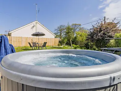 a large hot tub in the backyard of a house at 2 Bed in Llanon oc-96072 in Pennant