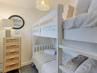 a bedroom with two bunk beds and a mirror at 2 Bed in Llanon oc-96072 in Pennant
