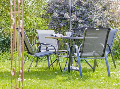 two chairs and a table with an umbrella in the grass at 2 Bed in Llanon oc-96072 in Pennant