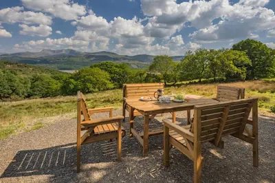 a wooden table and chairs with a view of the mountains at 3 Bed in Barmouth oc-c31942 in Barmouth