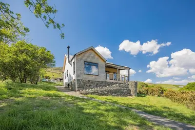 a cottage on a hill with a grassy field at 3 Bed in Barmouth oc-c31942 in Barmouth