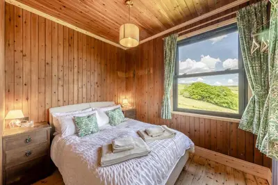 a bedroom with a bed in a wooden room with a window at 3 Bed in Barmouth oc-c31942 in Barmouth