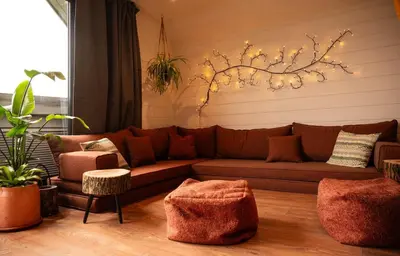 a living room with a brown couch and a tree at Oolert Treehouse in Hundred House
