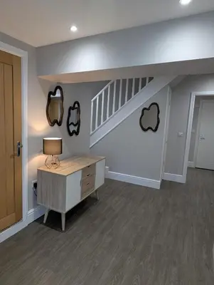 a living room with a desk and a staircase at Bwthyn Y Mor in Llanddwywe