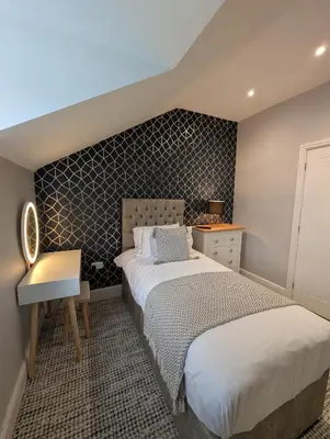 a bedroom with a bed and a desk and a bed sidx sidx sidx at Bwthyn Y Mor in Llanddwywe