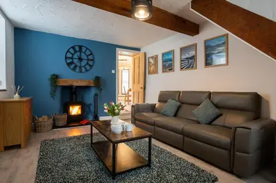 a living room with a couch and a fireplace at Cosy townhouse with log burner in Dolgellau