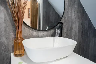 a bathroom with a white sink and a mirror at Cosy townhouse with log burner in Dolgellau