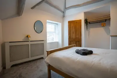 a bedroom with a bed and a mirror on the wall at Cosy townhouse with log burner in Dolgellau