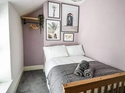 a small bedroom with a bed and some pictures on the wall at Beautiful cottage with log burner in Dolgellau
