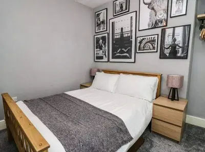 a bedroom with a bed with pictures on the wall at Beautiful cottage with log burner in Dolgellau