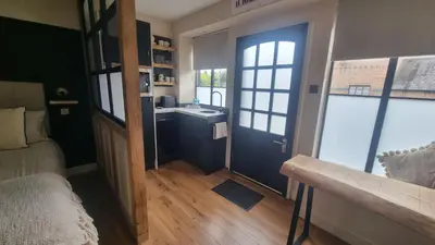 a room with a bathroom with a sink and a door at The Old Shop High Street in Llanidloes