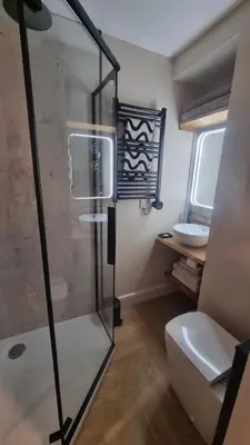 a bathroom with a shower and a toilet and a sink at The Old Shop High Street in Llanidloes