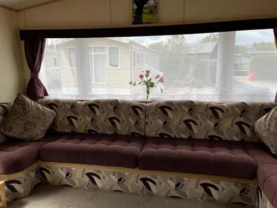 a couch in front of a window with flowers on it at Sylvan Near Hay on Wye in Rhos-gôch