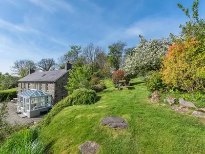 a garden with a greenhouse in front of a house at West Llwyn - Uk41757 in Rhyd Owen