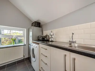 a kitchen with a sink and a refrigerator at West Llwyn - Uk41757 in Rhyd Owen