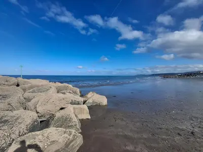a group of rocks on a beach near the water at 'Falcons Rest' in Borth