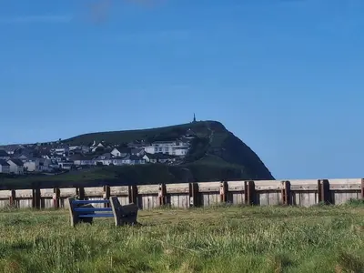 a blue bench sitting in a field next to a fence at 'Falcons Rest' in Borth