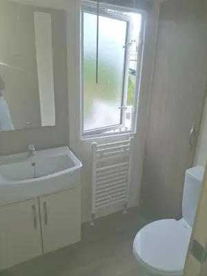 a bathroom with a sink and a toilet and a window at 'Falcons Rest' in Borth