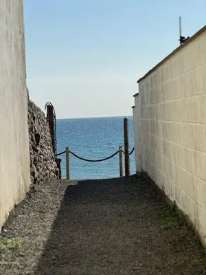 a retaining wall with the ocean in the background at Y Caban Caru in Tywyn