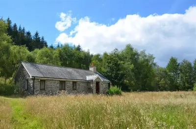 an old stone house in the middle of a field at Cae'n Y Coed Barn in Talsarnau