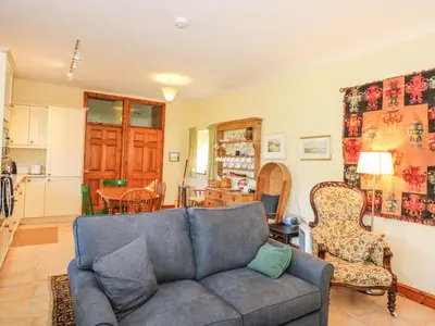 a living room with a couch and a kitchen at Cae'n Y Coed Barn in Talsarnau