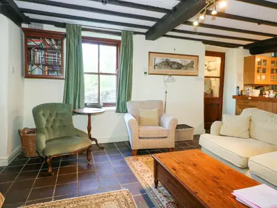 a living room with a couch and chairs and a table at Cae'n Y Coed Cottage in Talsarnau