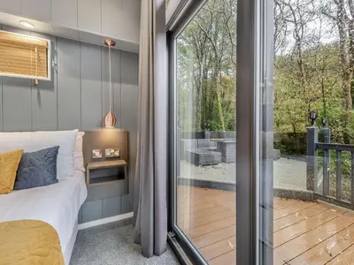 a bedroom with a bed and a sliding glass door at The Powys Lodge in New Quay