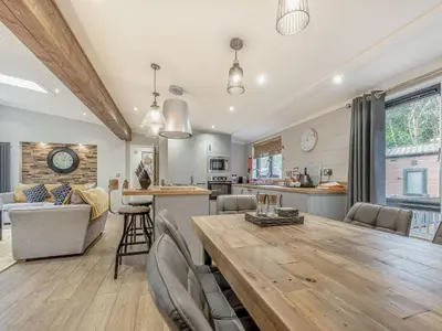 a kitchen and living room with a large wooden table at The Powys Lodge in New Quay