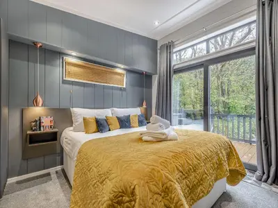 a bedroom with a large bed and a large window at The Powys Lodge in New Quay