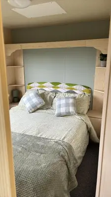 a bedroom with a bed with two pillows at Northfield Holiday Park in Borth