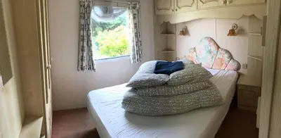 two towels sitting on a bed in a bedroom at Northfield Holiday Park in Borth