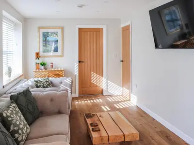 a living room with a couch and a wooden coffee table at Cae Cwta in Llanddwywe