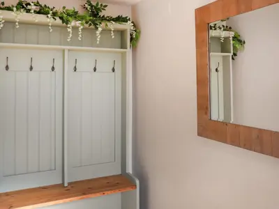 a room with white cabinets and a mirror at Cae Cwta in Llanddwywe