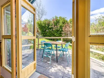 a room with a table and chairs on a balcony at 3 Legged Duck Cottage in Yspytty-Ystwyth