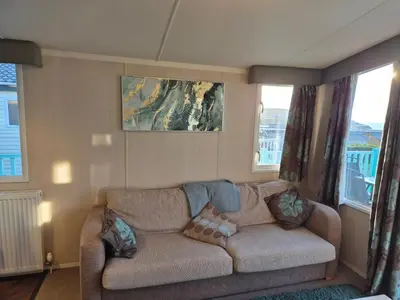 a living room with a couch and two windows at Caravan in Picturesque New Quay Wales in New Quay